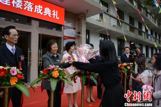 华侨大学学生向校董汪琼南女士(左二)献花。　张为健 摄